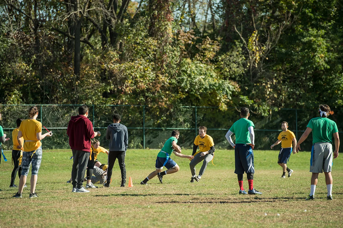 Medical and grad students running while playing flag football