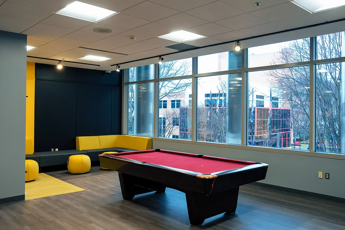 Billiard table and lounge seating in the Student Success Center's game room