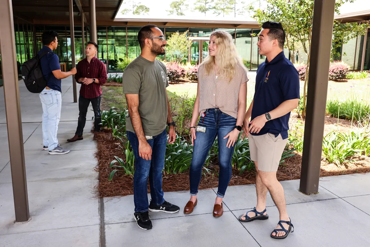 PCOM South Georgia grad students talking while standing in the Jeter Courtyard