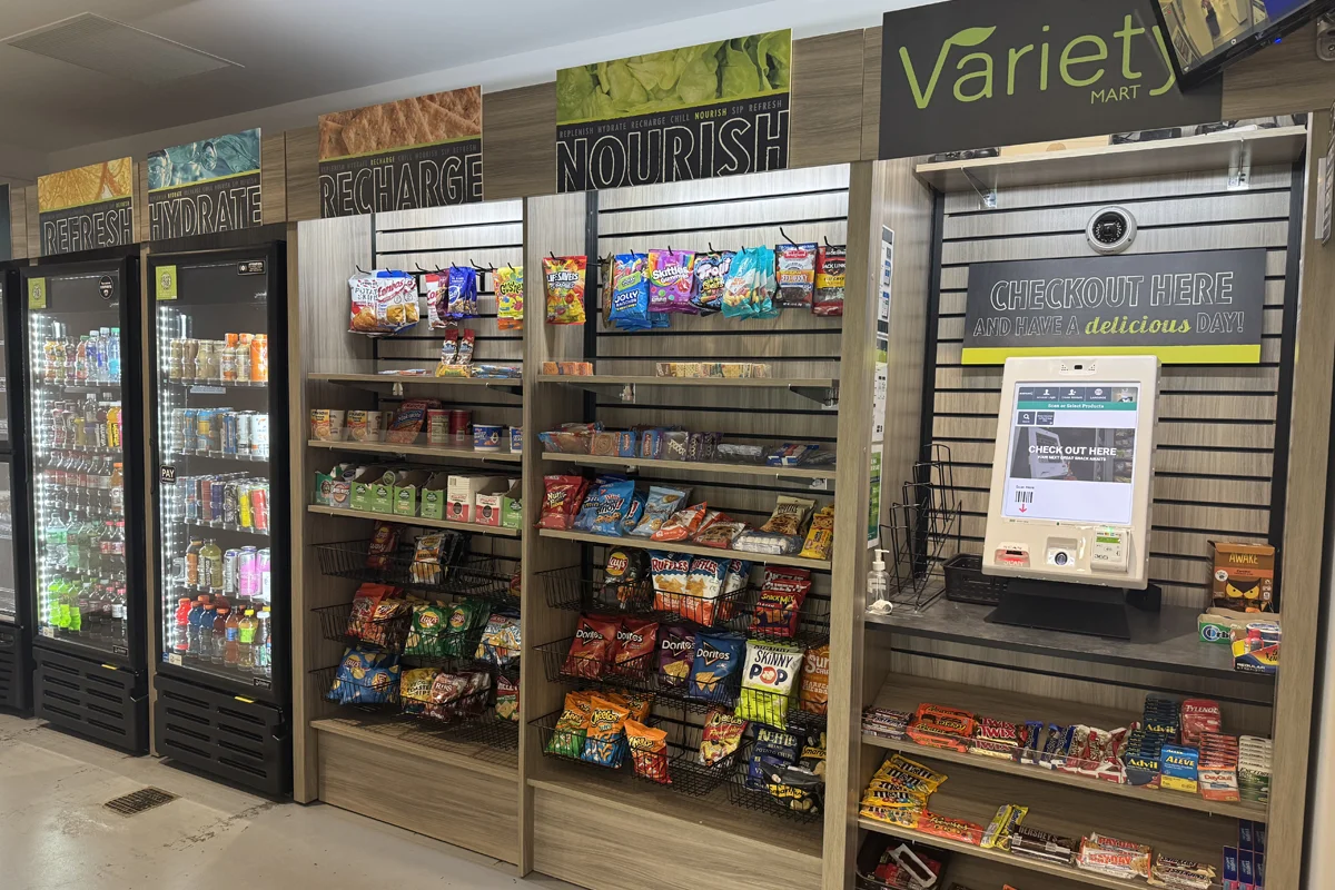 Market cafe with rows of snacks able to be purchased at a self-checkout digital kiosk
