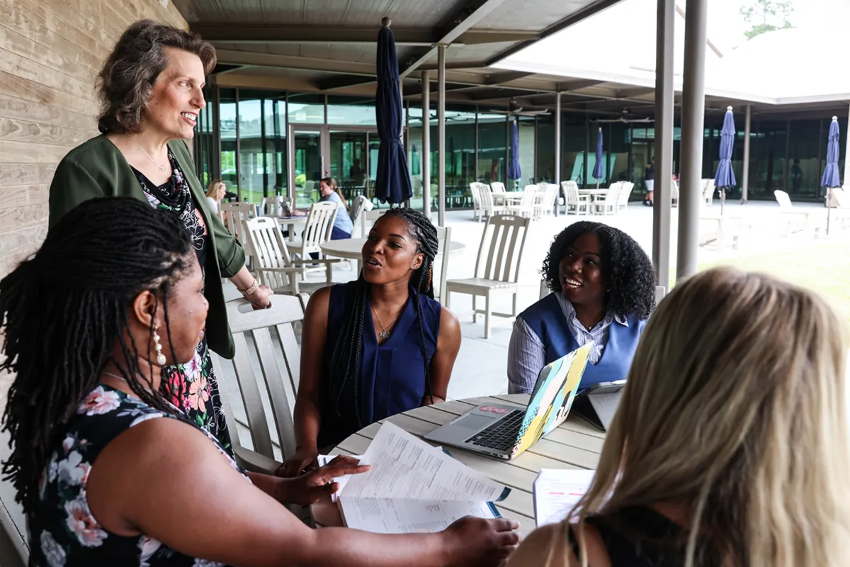 Staff and grad students talking and studying on a rear porch of PCOM South Georgia