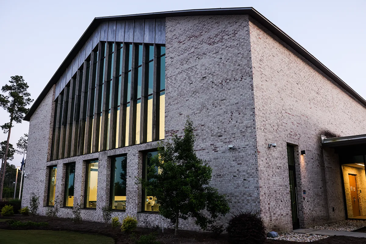 Looking up at the main architecture of PCOM South Georgia's front building at dusk