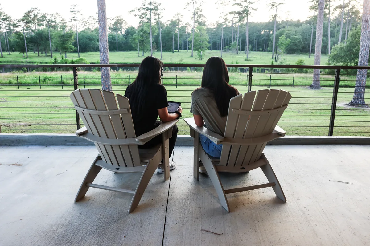 Student studying on chairs on a rear porch at PCOM South Georgia