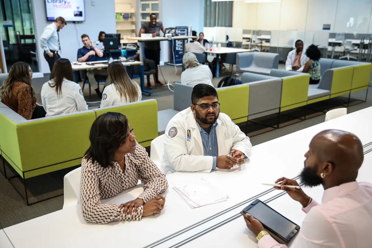 Students talking and collaborating while working in the Information Commons