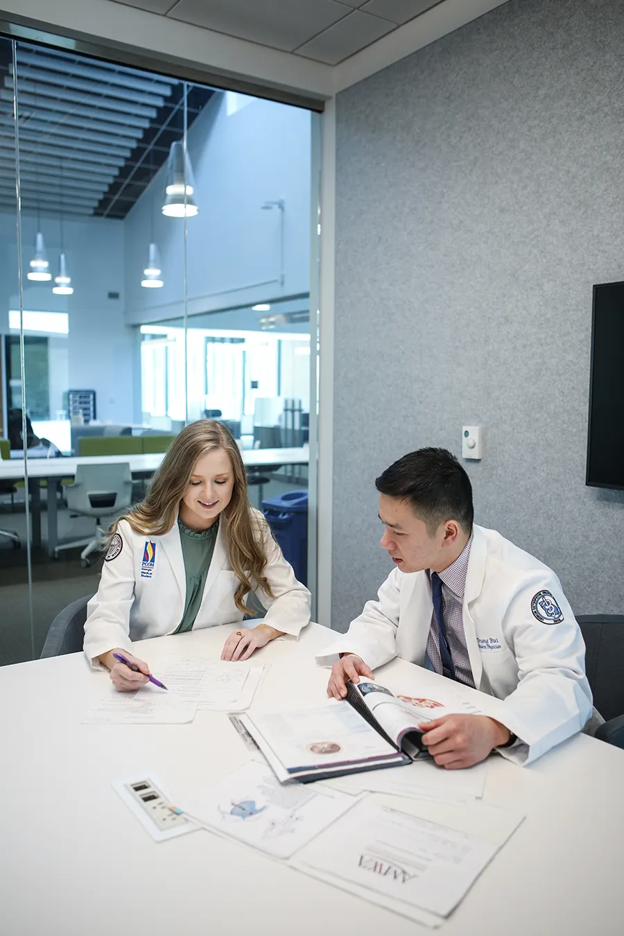 DO students smiling in a study area within the information commons