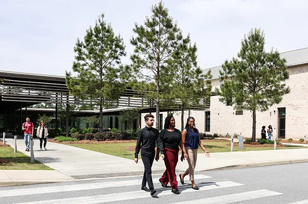 Front shot of PCOM South Georgia's main building and students walking outside