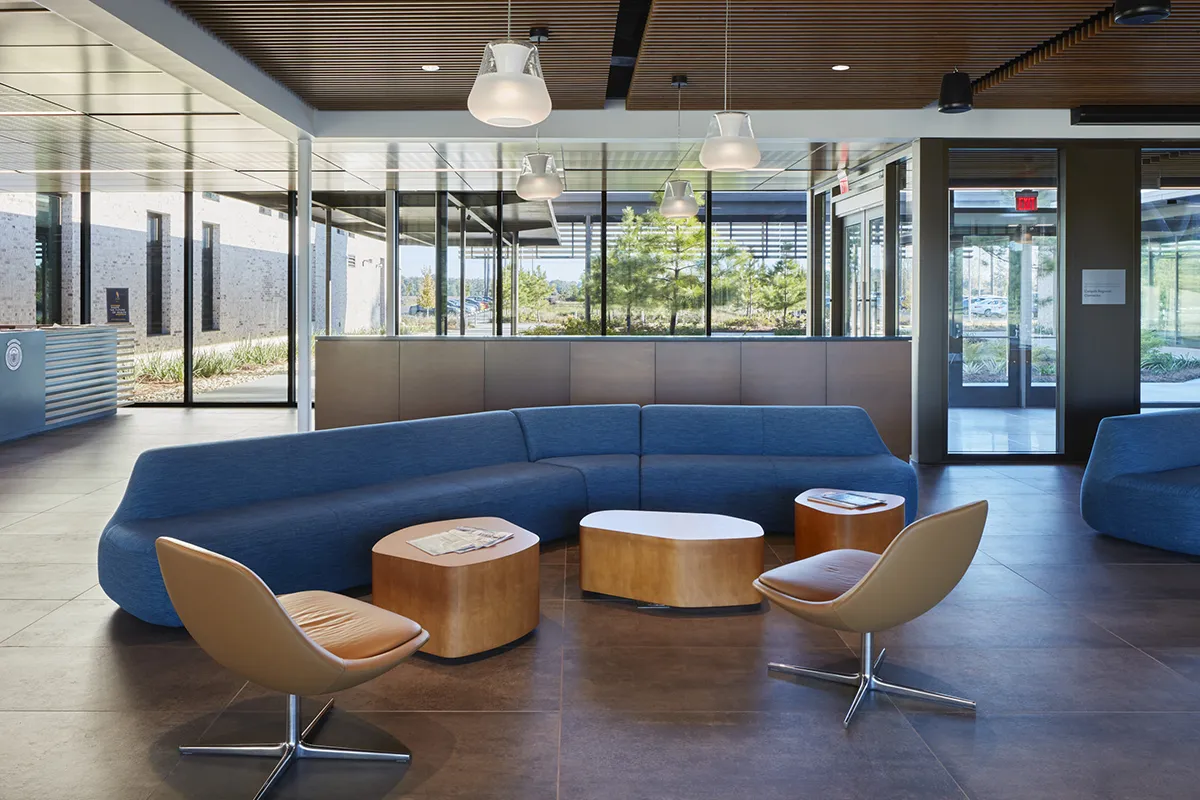 View of tables, chairs and windows within the Colquitt Regional Connector Lobby