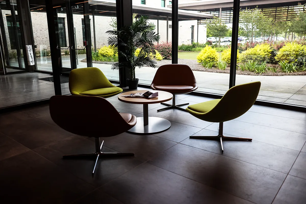 Table and chairs in front of a large window in the lobby