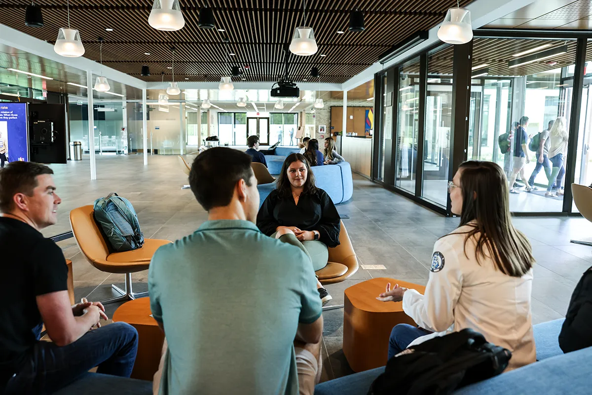 PCOM South Georgia graduate students sitting and talking in a busy Colquitt Regional Connector Lobby