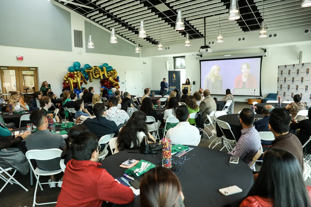 SGB/DeLoache room filled with folks smiling during a Match Day event