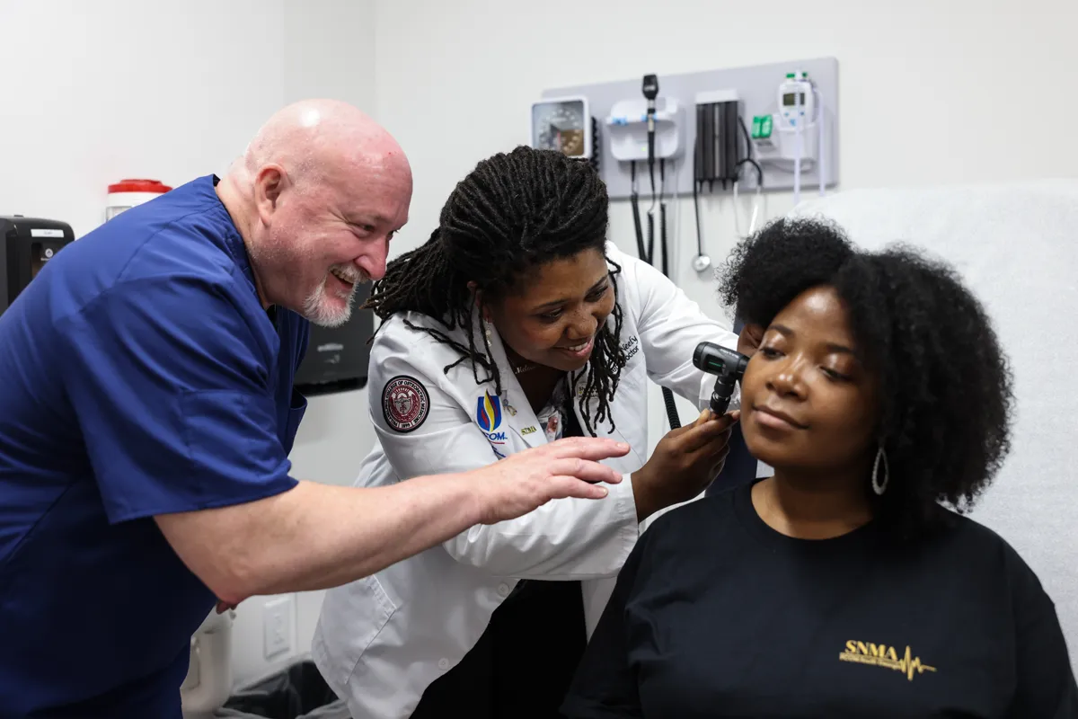 Faculty and med students practicing patient exam techniques in the Sim Center