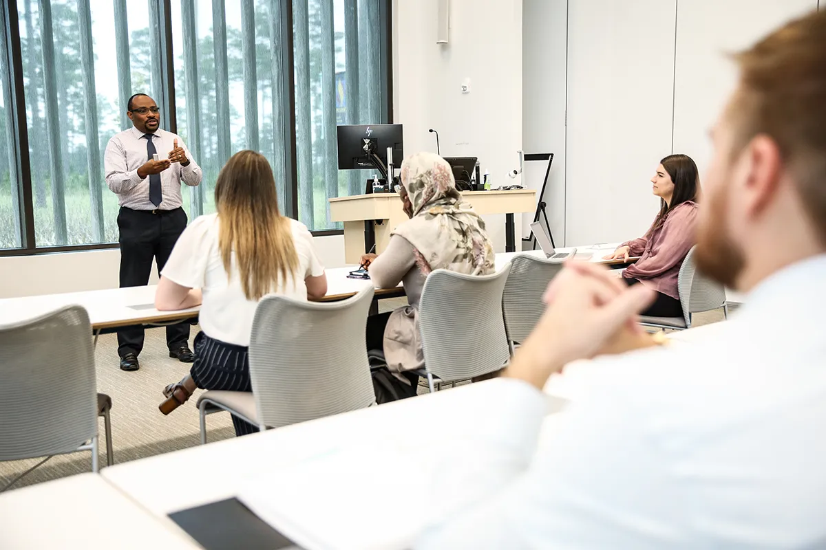 A professor lecturing grad students in a classroom at PCOM South Georgia