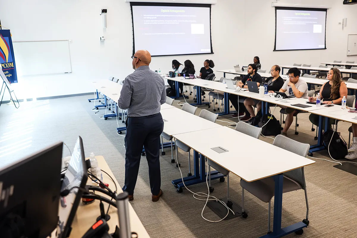 Faculty member teaching some students in a large classroom at PCOM South Georgia