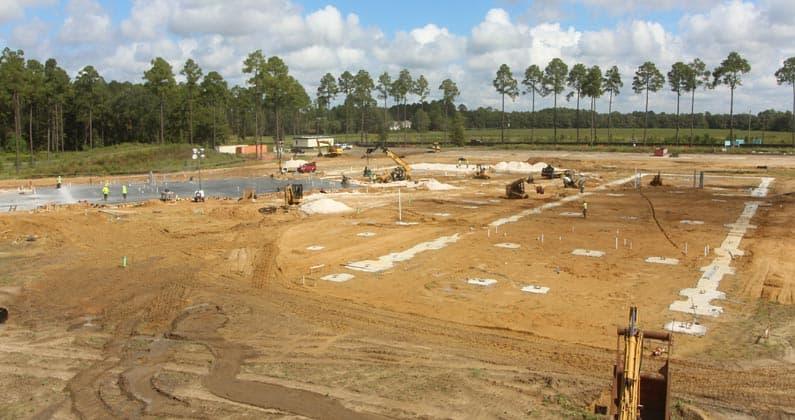 Contractors and equipment pour concrete at the PCOM South Georgia construction site.