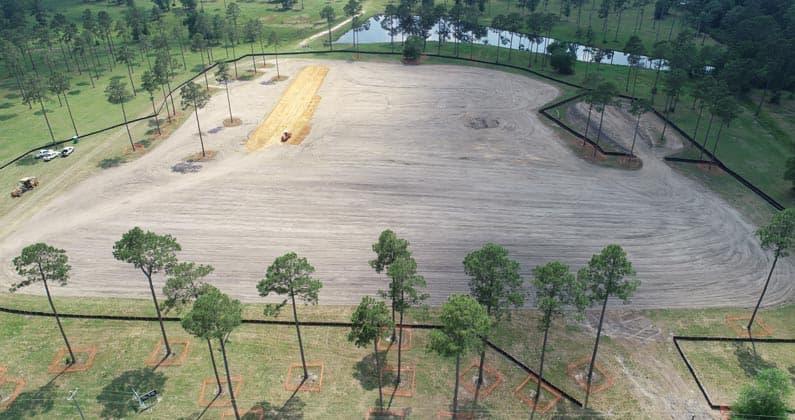 Aerial view of ground being leveled by equipment at PCOM South Georgia construction site.