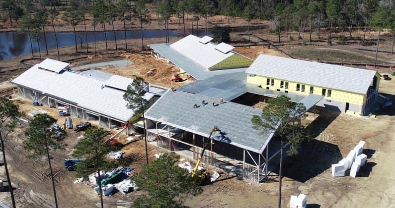 Walls and roof material are seen being constructed from an aerial view of PCOM South Georgia's site.