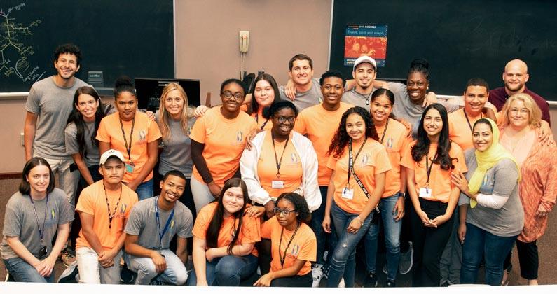 Philadelphia area high school students smile with PCOM students after graduating from the summer program.