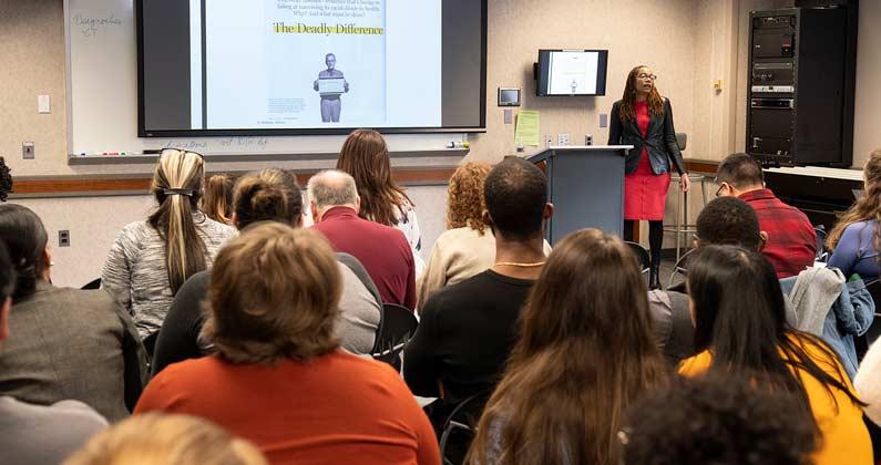 A guest speaker addresses students about racial justice issues during an MLK Day event at PCOM.