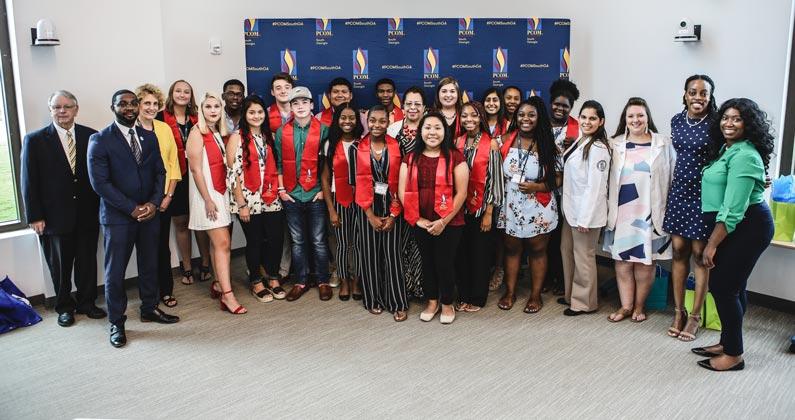 Gwinnett County high school students smile with PCOM South Georgia students and staff after graduating from the summer program.