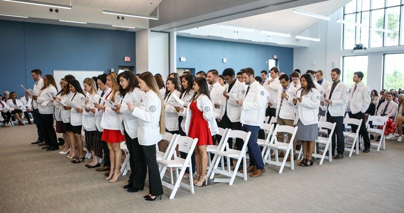 Medical students stand in the audience and clap.