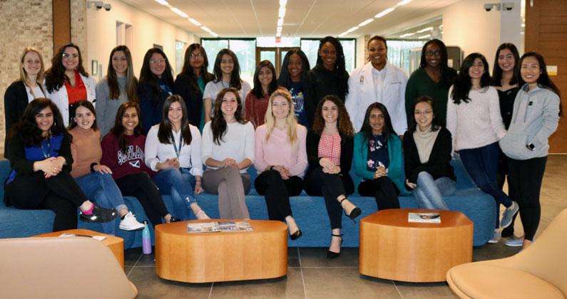 Women of the PCOM South Georgia DO Class of 2024 smile and pose in the lobby in August 2019.