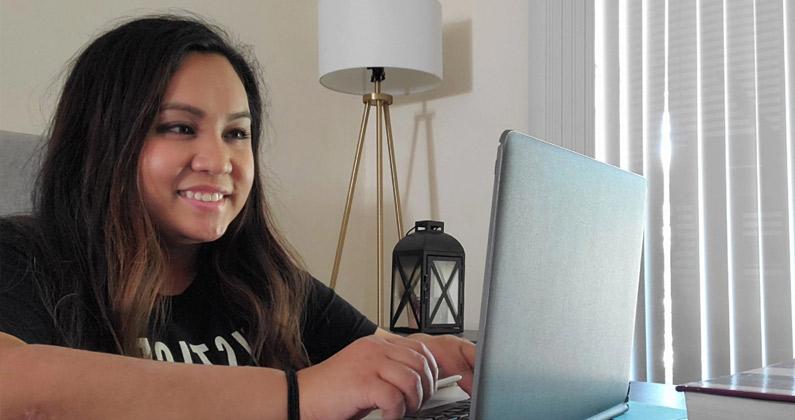 Doctor of Physical Therapy candidate Jill Le (DPT ’21) smiles as she works on a laptop in her apartment.