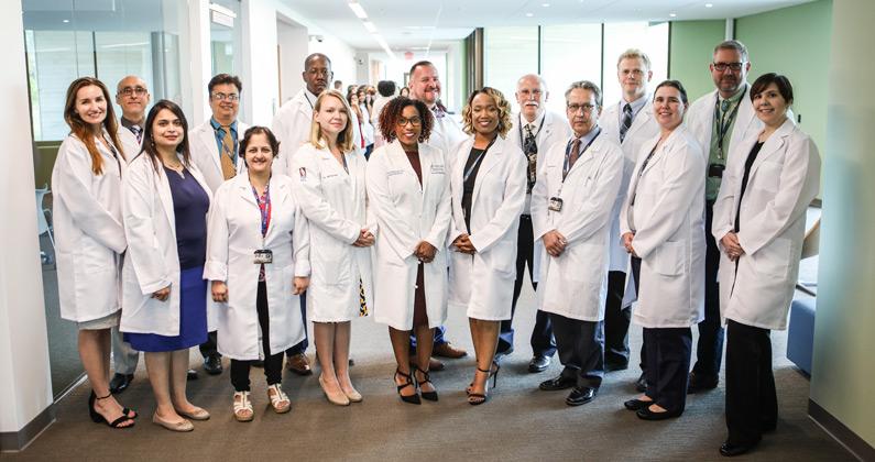 PCOM South Georgia faculty members pose for a group shot while wearing their white coats at PCOM South Georgia.