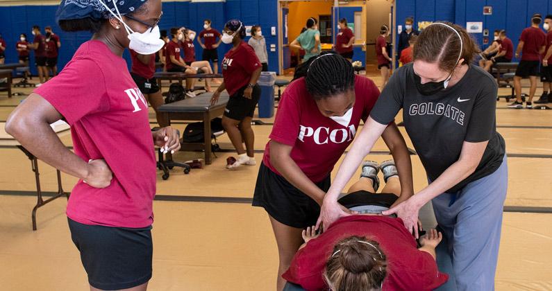PCOM faculty member Lauren Noto Bell, DO, helps a student perform a manipulation during an OMM lab session.