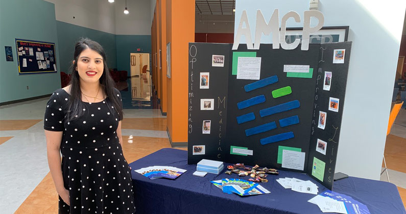 Kinjal Shah, PharmD, poses with her research poster at a PCOM Georgia pharmacy program event.