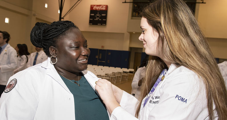 A DO medical student from the class of 2024 receives a pin.