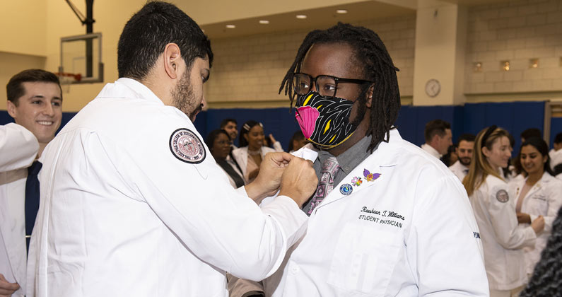 A DO medical student from the class of 2024 receives a pin.